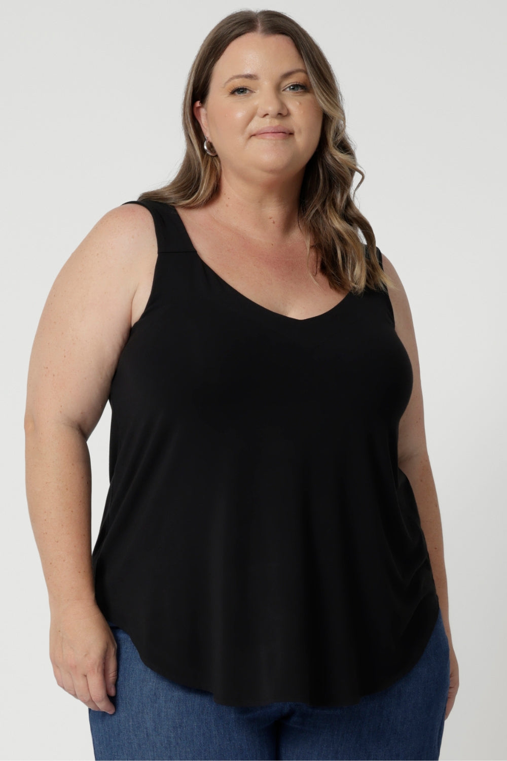 Size 18 woman wears summer ready cami in black colour. Ideal choice for warm weather, offering a breezy and flattering fit. The top features a graceful V-neckline both in the front and the back, adding a touch of sophistication and subtle femininity to the overall look. Available now in sizes 8-24.