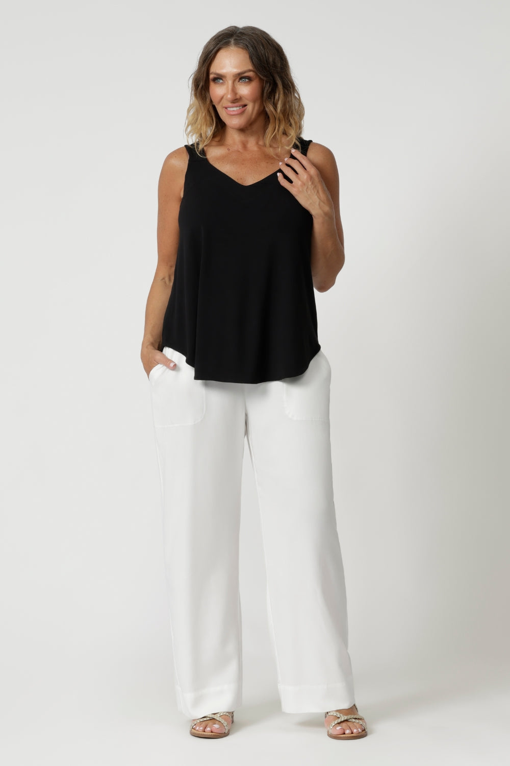 Size 12 woman wears summer cami, that features a shirt-tail hemline providing a relaxed, elongated silhouette, offering a flattering shape that drapes effortlessly over the body. Made from natural bamboo fibres, the fabric boasts exceptional thermoregulating properties, helping to cool the body on warm days and maintain comfort in fluctuating temperatures. This makes the cami perfect for travel, as it adapts to your environment, keeping you fresh and comfortable throughout your journey. Sizes 8-24 available
