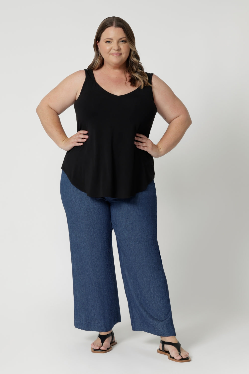 Over 40's woman wears bamboo cami in opal shade, paired back with denim pants, creating a summer ready casual look paired with some flat travel shoes. Cami is stocked in sizes 8-24.