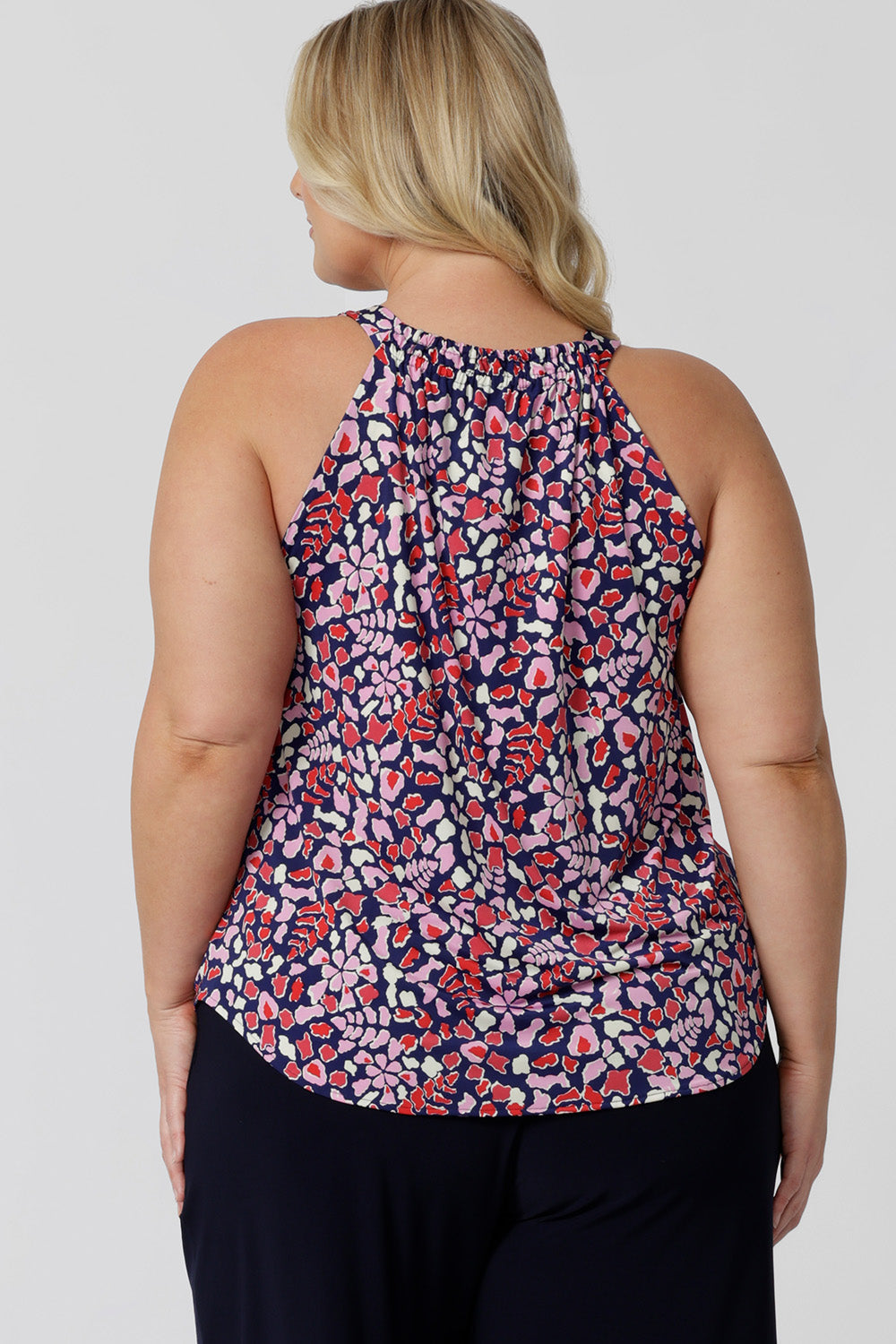 Back view of a summer top for over plus size women. This halter neck top is a comfortable, easy-care top worn with white pants for summer. In red, pink, white and navy print, this plus size jersey top is a made in Australia top by Australian and New Zealand women's clothes brand, Leina & Fleur, shop their petite to plus size tops online.