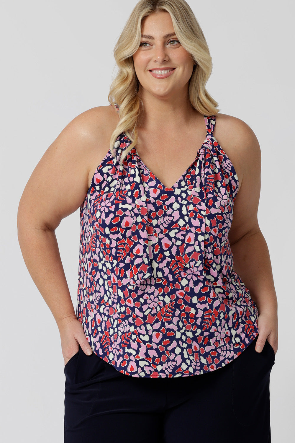 A good summer top for plus size women, this halter neck top is a comfortable, easy-care top. Shown ona. size 18 woman as a plus size and curve top, in red, pink, white and navy print, this slinky jersey top is a made in Australia top by Australian and New Zealand women's clothes brand, Leina & Fleur, shop their petite to plus size tops online.