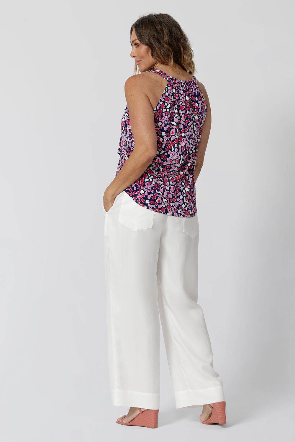 BAck view of a summer top for over 40s women. This halter neck top is a comfortable, easy-care top worn with white pants for summer. In red, pink, white and navy print, this slink jersey top is a made in Australia top by Australian and New Zealand women's clothes brand, Leina & Fleur, shop their petite to plus size tops online.