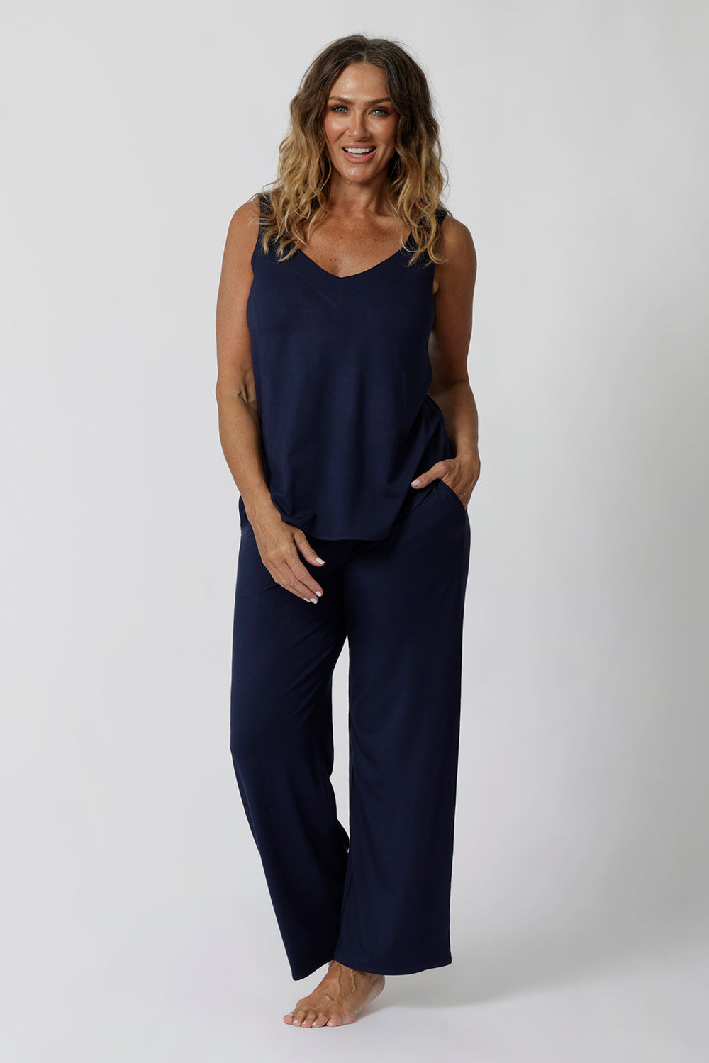 Showing good lounge pants for over 40s women, a size 12 woman wears straight, wide leg navy blue, plus size lounge pants in bamboo jersey with a blue bamboo jersey cami top. Breathable and thermo-regulating this is a good pyjama set for night sweats and hot flushes. Stay cool for summer nights with breathable sleepwear by L&F Australia in sizes 8-24.