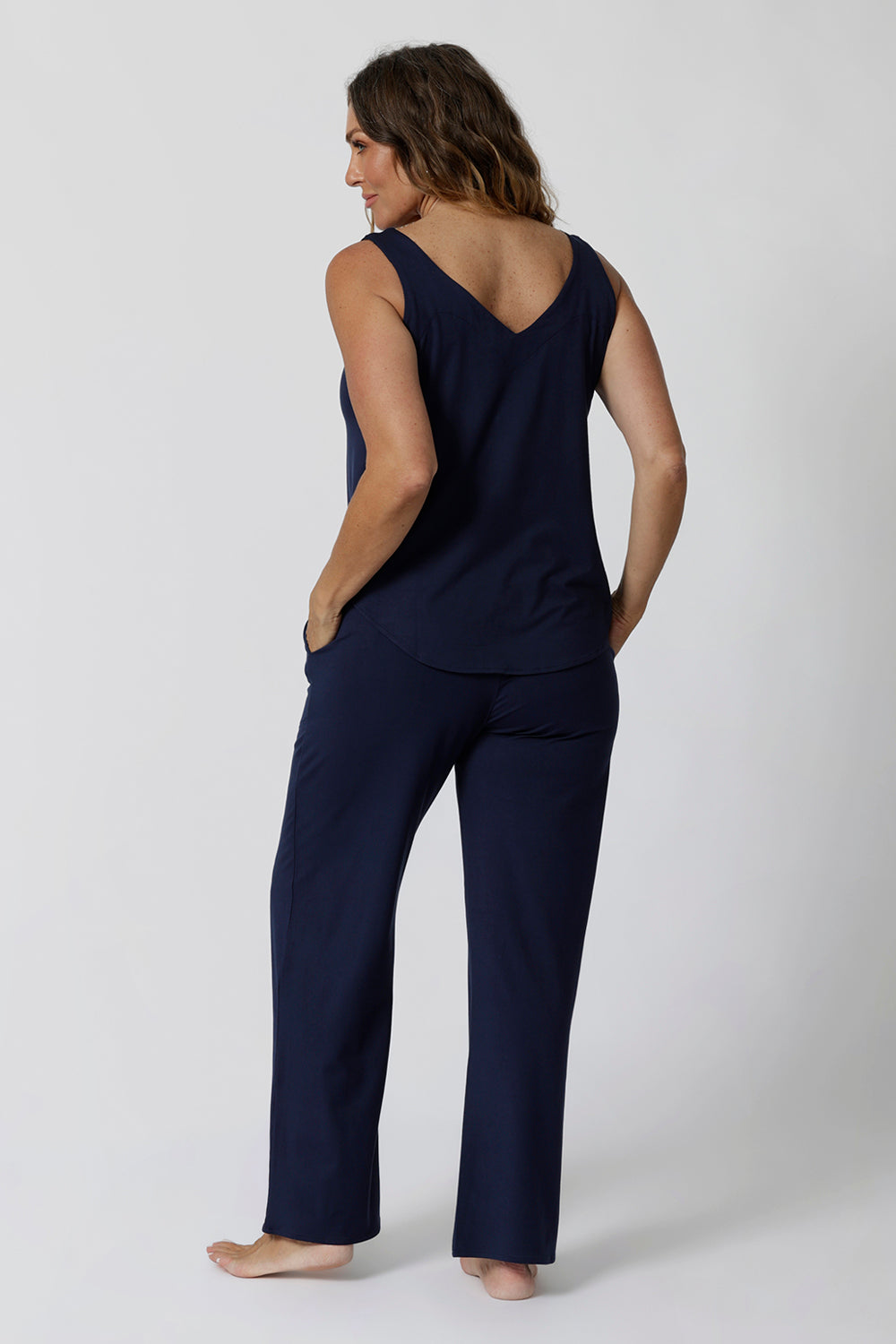 Back view of good lounge pants for over 40s women, a size 12 woman wears straight, wide leg navy blue, plus size lounge pants in bamboo jersey with a blue bamboo jersey cami top. Breathable and thermo-regulating this is a good pyjama set for night sweats and hot flushes. Stay cool for summer nights and shop breathable sleepwear by L&F Australia in sizes 8-24.