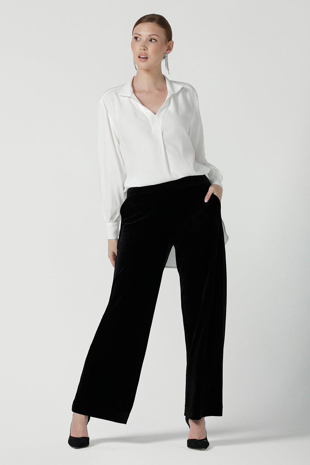 A size 10 woman wears the Ellis shirt in Vanilla tencel, a high quality made in Australia womens shirt made in breathable tencel. Inclusive size range 8-24 and made in Australia. Styled back with the Deni pants in Black velour.