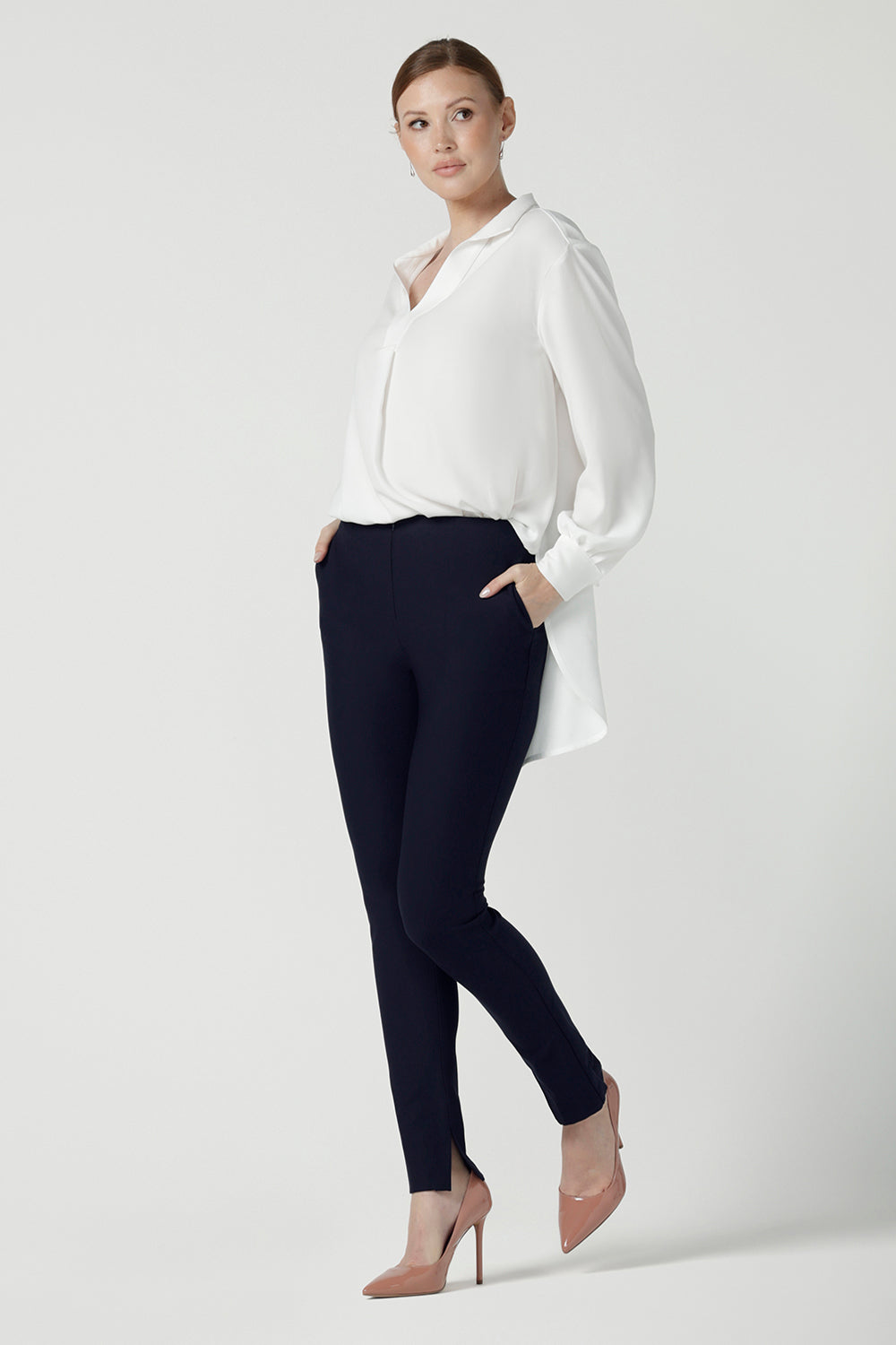 A size 10 woman wears the Ellis shirt in Vanilla tencel, a high quality made in Australia womens shirt made in breathable tencel. Inclusive size range 8-24 and made in Australia. Styled back with the Diaz pant in navy ponte.
