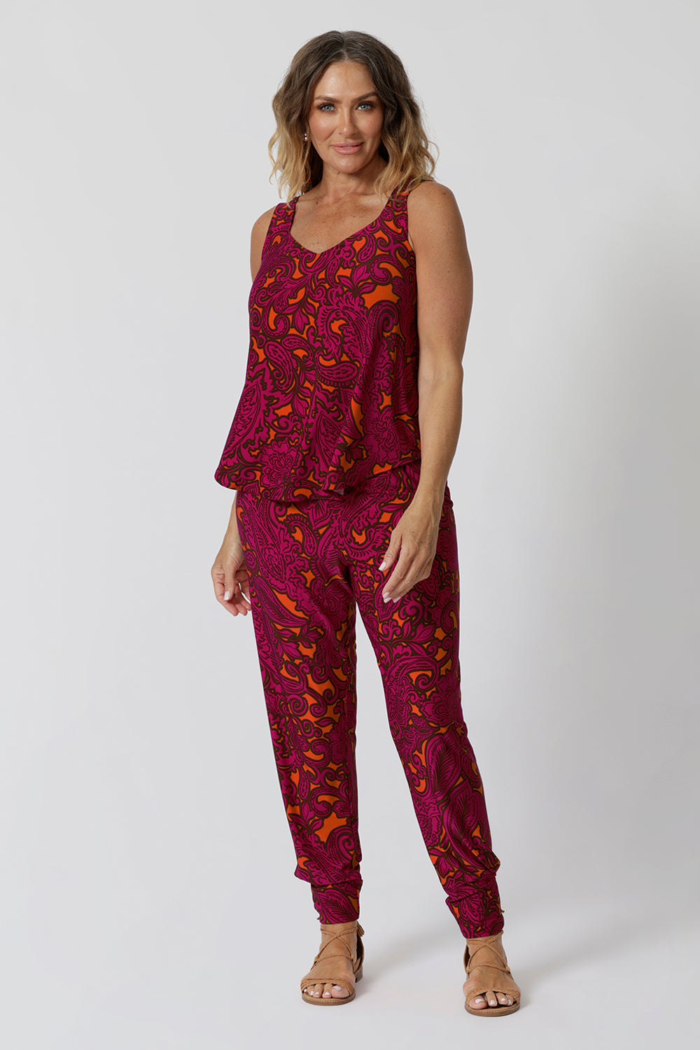 40 year old model wears paisley printed pant with matching paisley printed cami for a relaxed coord set. Practical and comfortable can be dressed up, worn casual or used for light exercise.