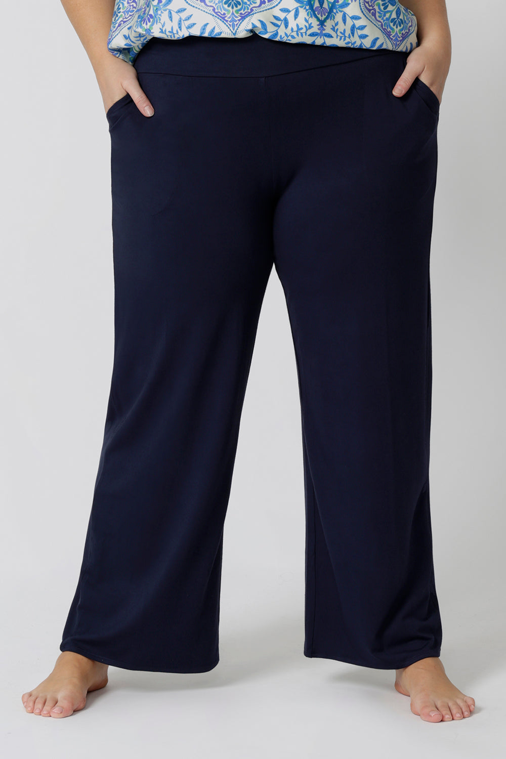 Close up of good lounge pants for curvy women. A size 18 wears straight, wide leg navy blue, plus size lounge pants in bamboo jersey with a blue and white print modal cami top. Breathable and thermo-regulating this is a good pyjama set for night sweats and hot flushes. Stay cool this summer nights with breathable sleepwear by L&F Australia.
