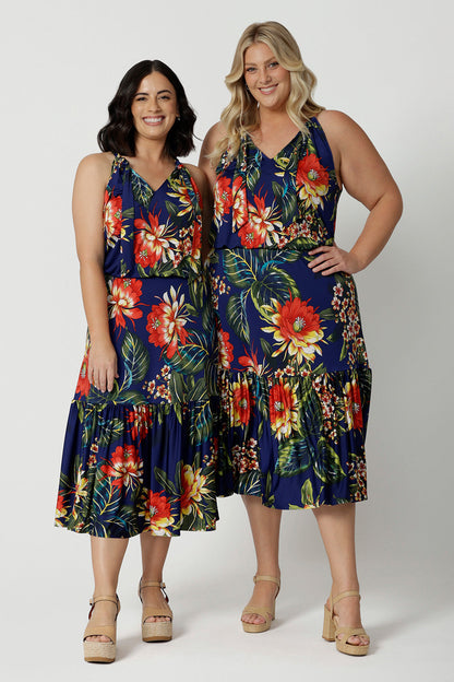 Full body image of two woman of different heights wearing the Darci Knee Length Dress in Bahagia. Floral halter dress is stocked in petite and plus sizes. This resort ready dress is made from slinky jersey fabric.This resort style dress is perfect for travel as the fabric is wrinkle resistant. Leina & Fleur is a woman's brand that stock sizes from 8 to 24.