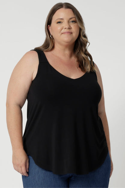 Size 18 woman wears summer ready cami in black colour. Ideal choice for warm weather, offering a breezy and flattering fit. The top features a graceful V-neckline both in the front and the back, adding a touch of sophistication and subtle femininity to the overall look. Available now in sizes 8-24.