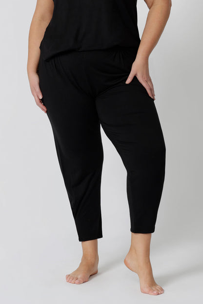 Close up of a good loungewear pant for curvy women. These black tapered, plus size pants are pull-on pyjama pants. Worn with black bamboo cami top, this is a breathable, thermo-regulating pyjama set and makes get sleepwear for night sweats and hot flushes. Shop loungewear sets online at L&F Australia.