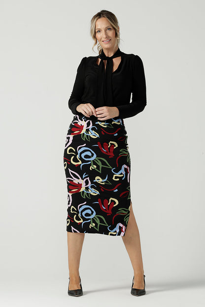 Size 10 woman wears the Boronia Midi Skirt back with a black tie neck top. Made in Australia for women size 8 - 24. 