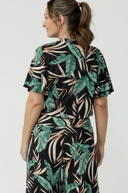 Tropical printed shrug cardigan. Featuring a leaf print on a black background. Ruched waist tie detail tie detail. Great layering piece. Ladies inclusive sizing. Size 8 pictured. 