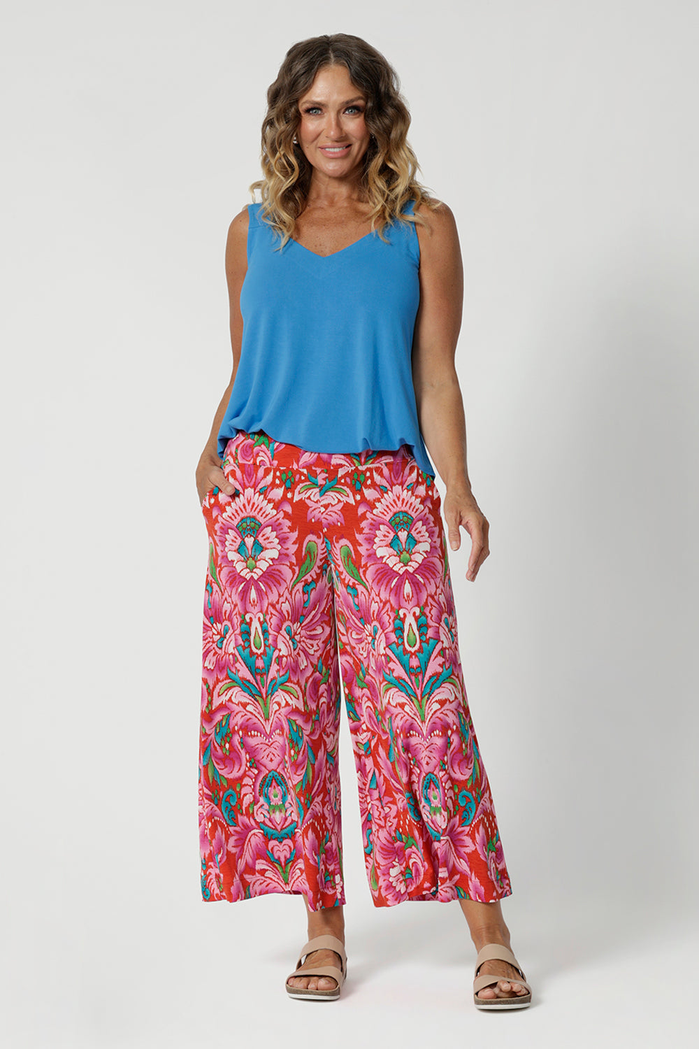 Bamboo summer cami is a perfect blend of elegance and functionality, crafted from luxurious, high-quality bamboo fabric in a serene opal colour. Its sleek, sleeveless design makes it an ideal choice for warm weather, offering a breezy and flattering fit. Model pairs bright cami with printed pants for a summer ready outfit. 