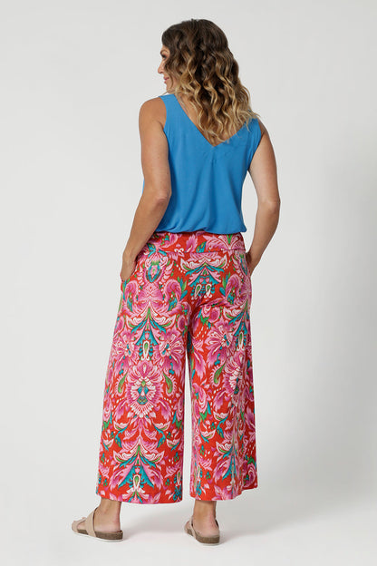 Over 40's woman wears bamboo cami in opal shade, paired back with brightly printed pants, creating a summer ready casual look paired with some flat travel shoes. Cami is stocked in sizes 8-24.