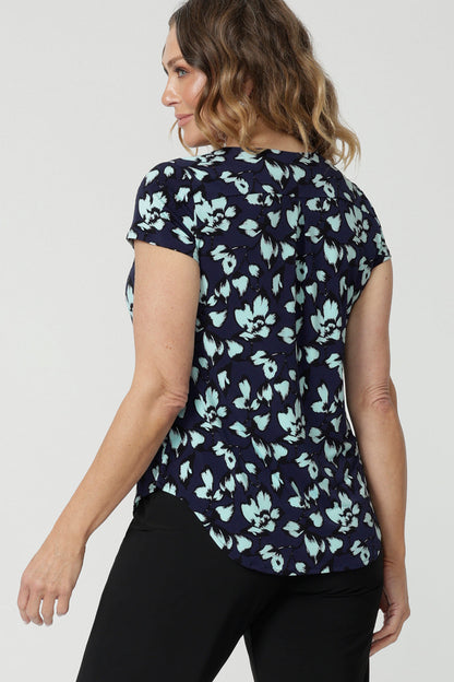 Back view of a good summer top for women. Show on a size 12, over 40s woman , this is the back of a cowl neck top in aqua blue floral print. A short sleeve top for summer, this comfortable top is made from stretch jersey and is an easy-care top style. Made in Australia by Australian and New Zealand women's clothes brand, Leina & Fleur.