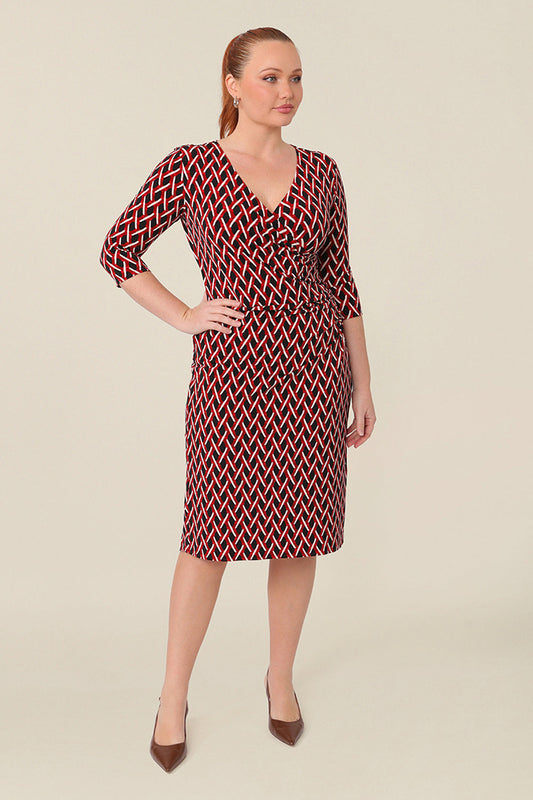 A curvy woman wears a fitted wrap front dress with 3/4 sleeves by Australian fashion brand, Leina & Fleur. A good workwear dress, in printed jersey this is an easy-care dress for work wear capsule wardrobes.