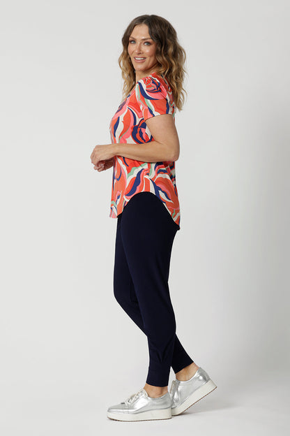 A good top to wear on a cruise, this  tailored T-shirt top for summer, is a V-neck top with short sleeves. Made in comfortable jersey, this printed top for women is worn by a size 12, over 40s woman.  Worn with tapered leg travel pants, this casual top  is good for travel and cruise wear. Made in Australia by Australian fashion brand, Leina & Fleur in sizes 8 to 24.