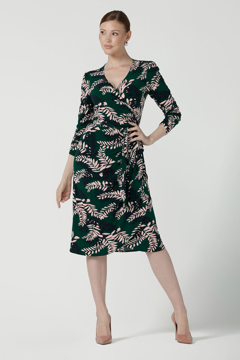 A size 10 model wears the Alpine Fern Heather dress in jersey. Made in Australia for women size 8 - 24. Fern green with leaf print all over. 