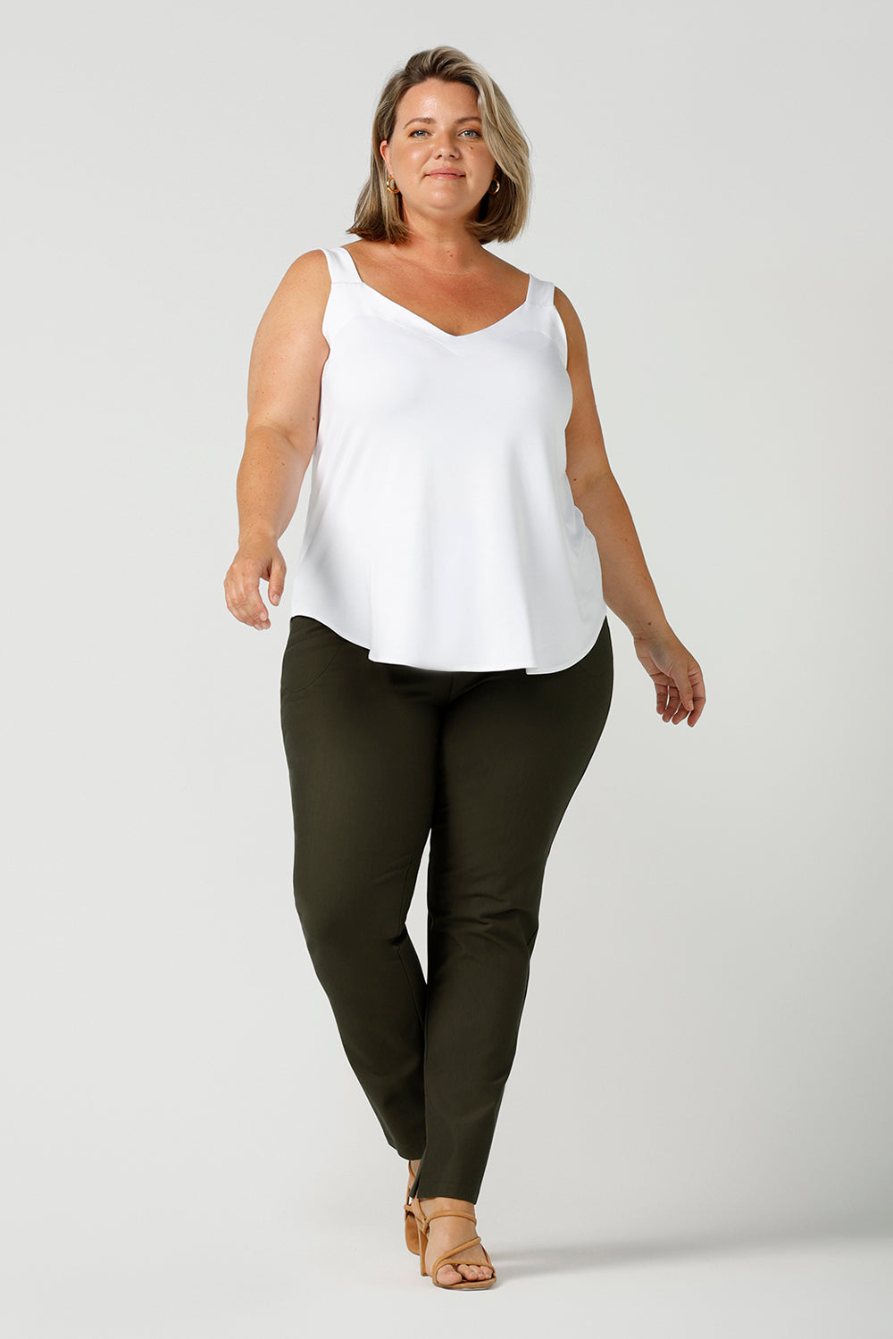 a plus size 18, fuller figure woman wears a bamboo cami with olive pants. In white bamboo jersey, this top is a good addition to your capsule wardrobe for weekend wear, work and travel. Shop Australian-made dresses online is sizes 8 to 24.