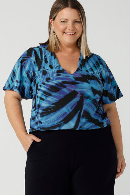 Curvy size 18 woman wears an Lila printed top in Flutter print. Digitally printed with cobalt, purple and black on a butterfly wing abstract print. Made in Australia for women 8 - 24.
