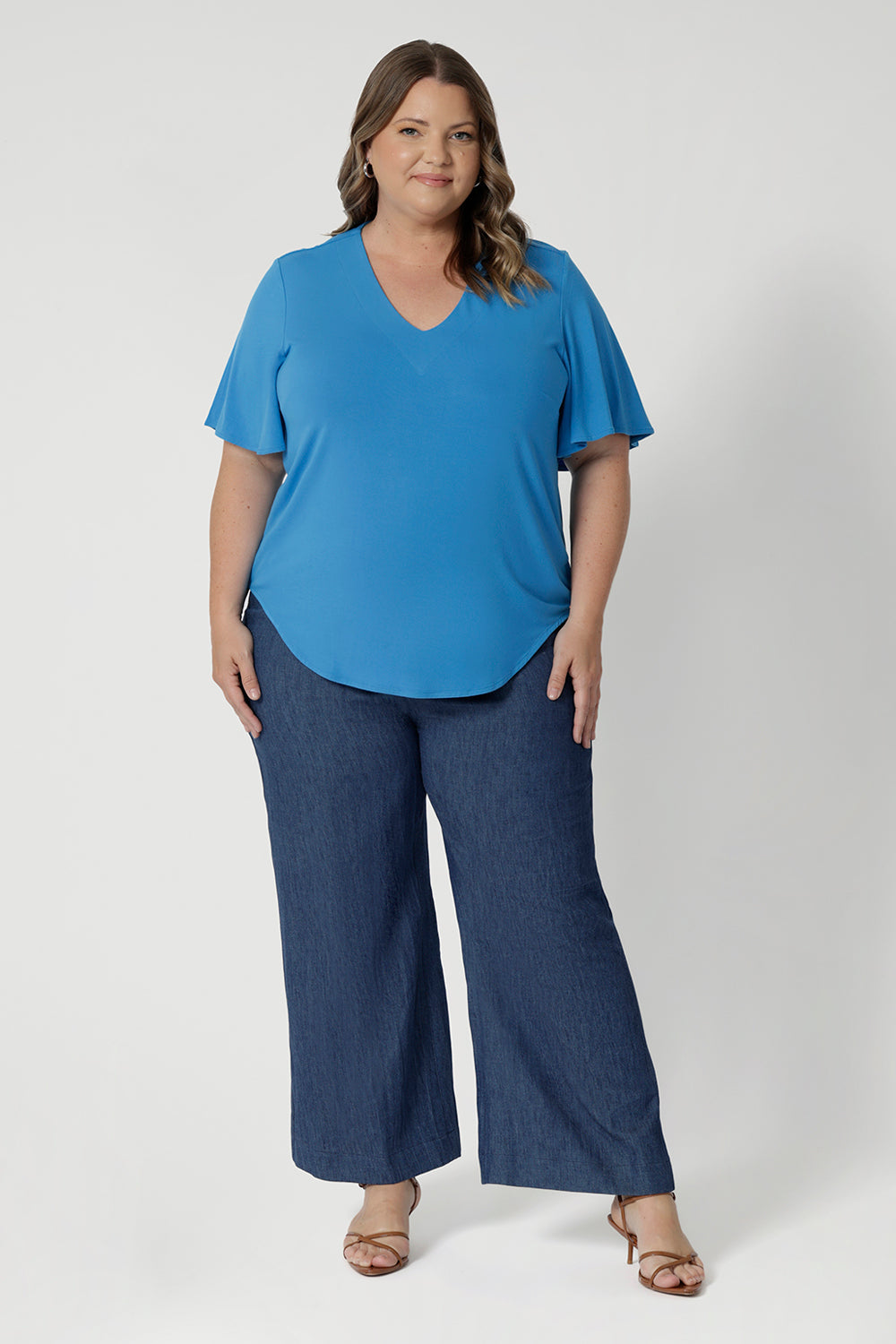 This women's summer top is a sophisticated blend of style and comfort, crafted from high-quality bamboo fabric. This top has a smooth, soft texture. Featuring beautiful flattering flutter sleeves that gently move with the body,  V-neckline enhancing the feminine silhouette and shirt-tail hemline to provide subtly curves and a relaxed fit that suits all body types.