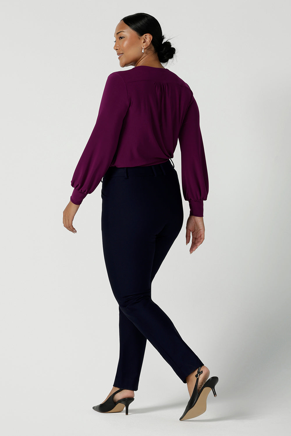 Back view of Lulu tailored pant in Navy. Made in Australia for women. Made in Australia for women size 8 - 24. A tailored pant in Navy with waistband and fly front with pockets. Styled back with the Avery top in Magenta. Proudly made in Australia.