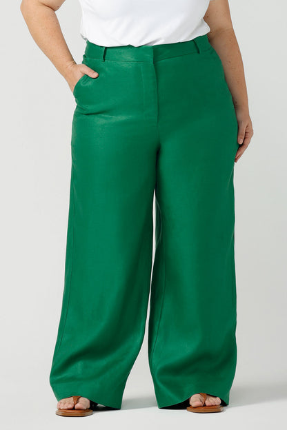Close up of a size 18 curvy woman wears a tailored linen pant in 100% linen. Breathable linen fabrication in a beautiful emerald green colour. The perfect workwear pants with pockets that make great summer pants. Size inclusive fashion designed and made in Australia size 8 - 24. 