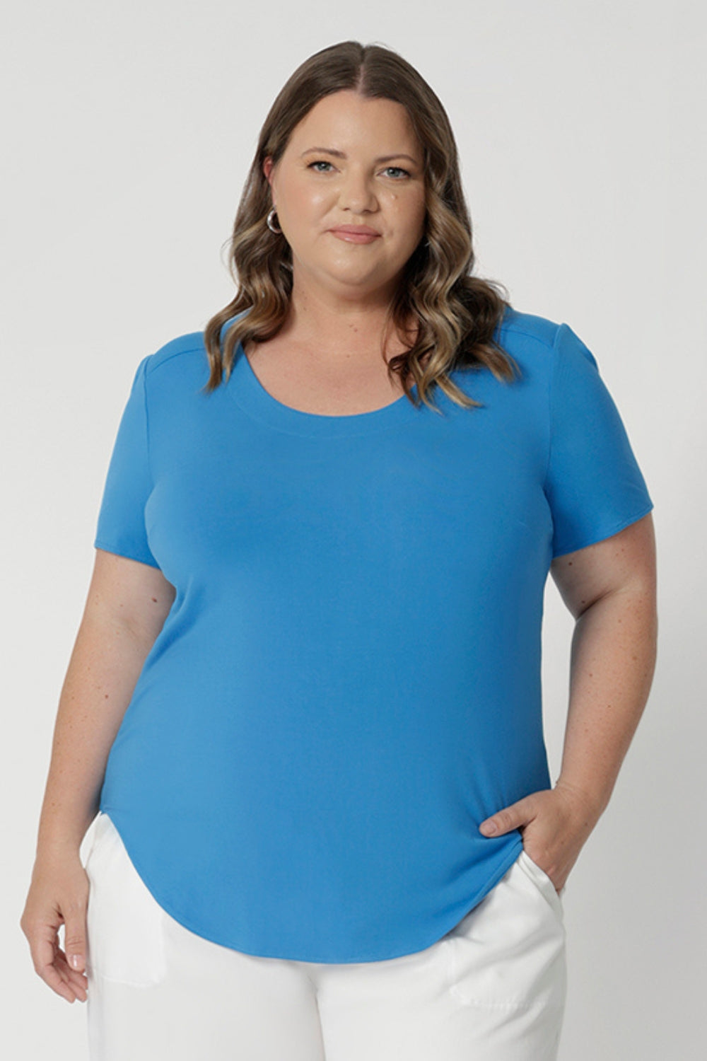 Plus size model styles bold top with white comfortable pants and a brown sandal doe a casual yet stylish everyday look. Add this stylish yet versatile piece to your wardrobe. Shop now in sizes 8-24.