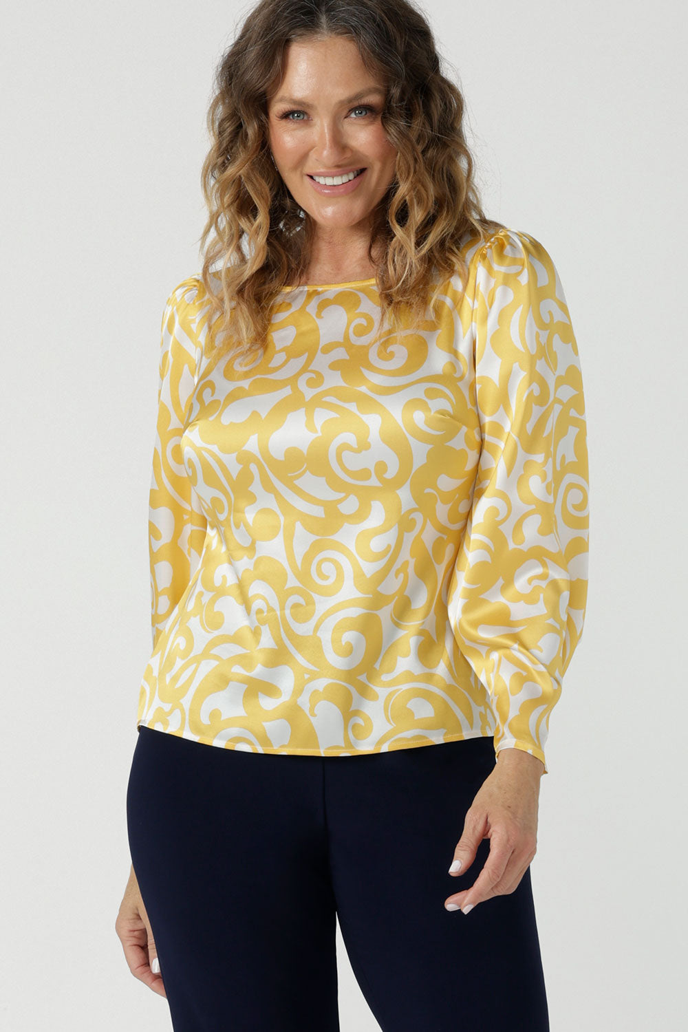 A size 10 woman wears a Zara Top in Yellow Swirl silk. A long sleeve blouse with fashion sleeve and made in 100% silk. Made in Australia for women size 8-24