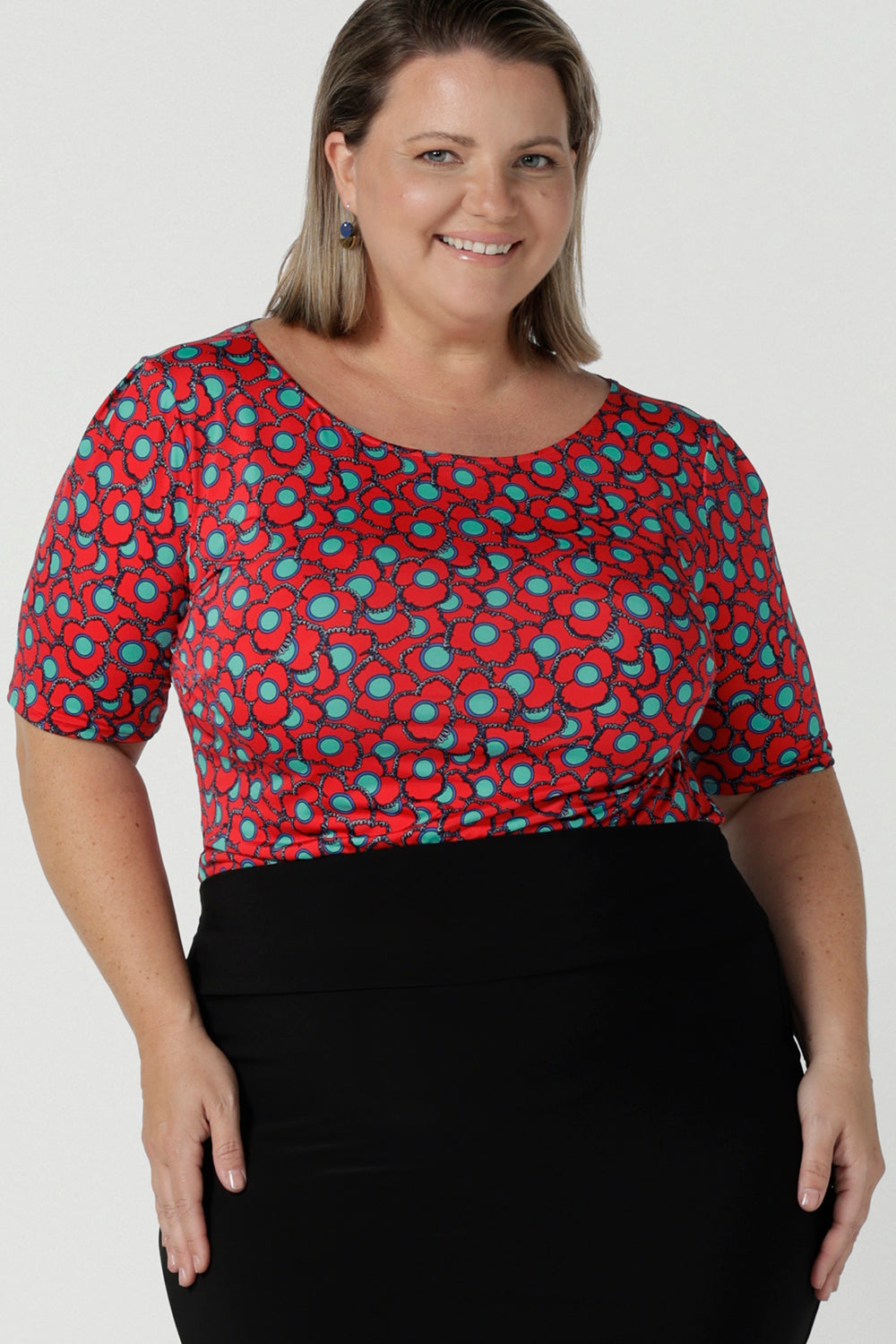 Size 12 woman wears the Ziggy top in Rio with a red base and seventies style floral. Round and conservative neckline. Short sleeve and made in Australia for women size 8 - 24.