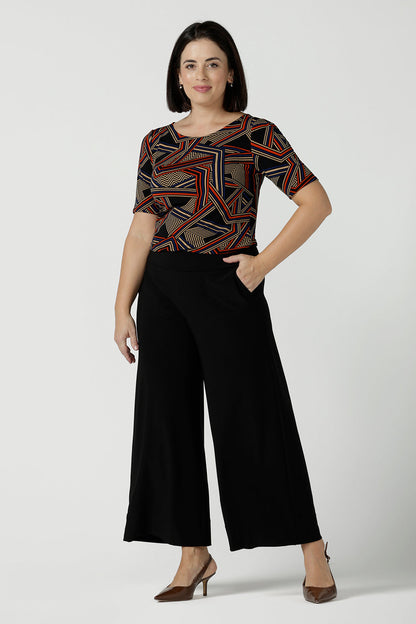 Size 10 woman wears the Ziggy Top in Trixe, a jersey boat neckline top and short sleeves. Conservative boat neckline and softly curved hem. Easy care jersey and size inclusive for petite to plus size. Made in Australia for women size 8 - 24.