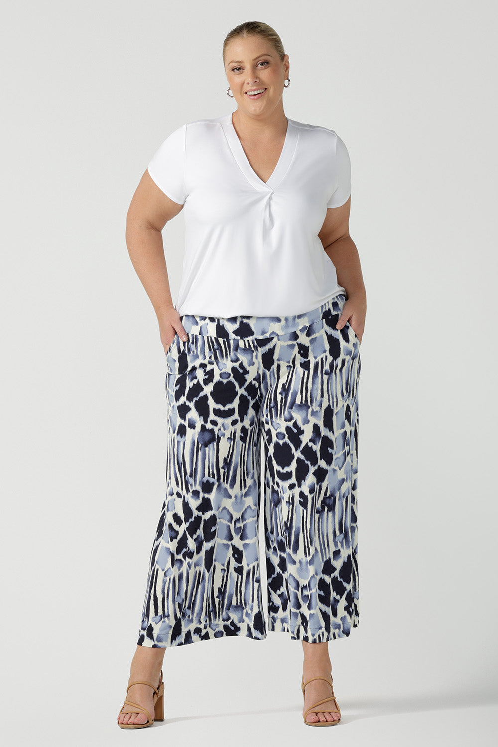 A size 18, plus size woman wears cropped, wide leg culotte pants in blue and white print with a short sleeve, white top in bamboo jersey. Great summer pants, these culottes are easy care and comfortable as work wear pants or for casual wear. Made in Australia by Australian women's clothing brand, Leina & Fleur