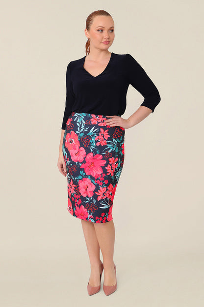 Size 12 curvy model wears good work wear for plus size women, a knee-length tube skirt in floral print is worn with a 3/4 sleeve top in navy. Made in Australia, shop this work skirt online in sizes 8 to 24.
