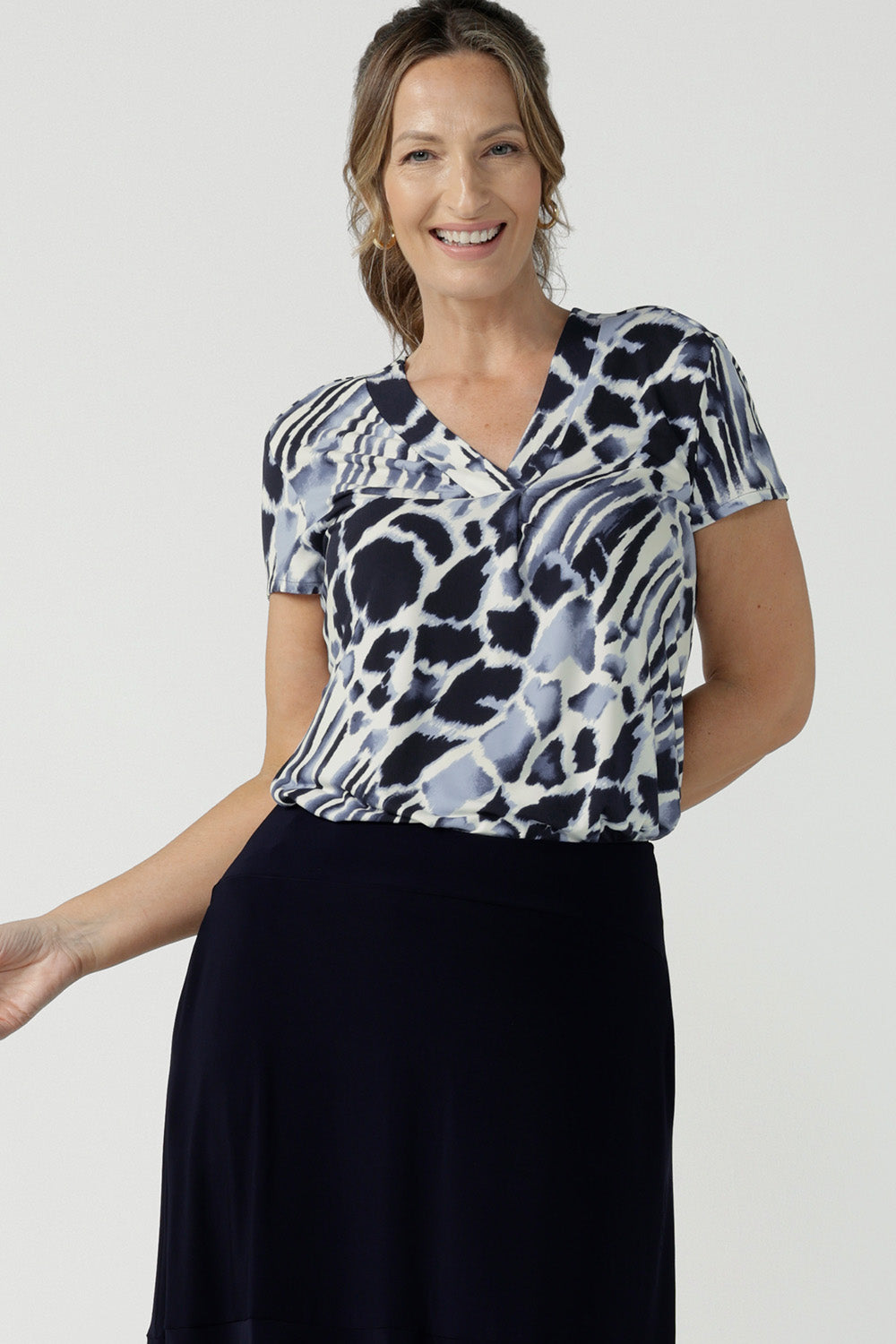 A good top for curvy women, this short sleeve V-neck top is tailored to fit women's curves. Shown on a size 10, 40 plus woman, this blue and white print jersey top is Australian-made. Wear this top for work and casual wear. Shop online in inclusive sizes 8 to 24 at Australian women's clothes brand, Leina & Fleur.