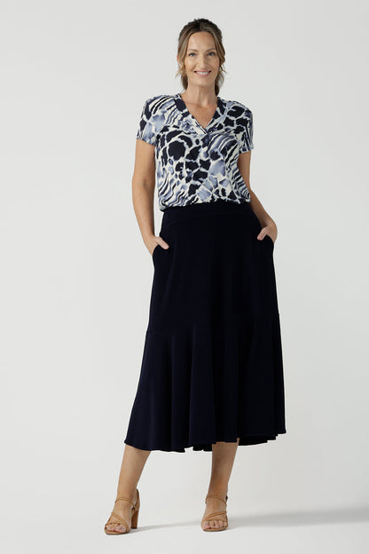 A good top for curvy women, this short sleeve V-neck top is tailored to fit women's curves. Shown on a size 10, 40 plus woman and worn with a navy blue maxi skirt, this blue and white print jersey top is Australian-made. Wear this jersey top for work and casual wear. Shop online in inclusive sizes 8 to 24 at Australian women's clothes brand, Leina & Fleur.
