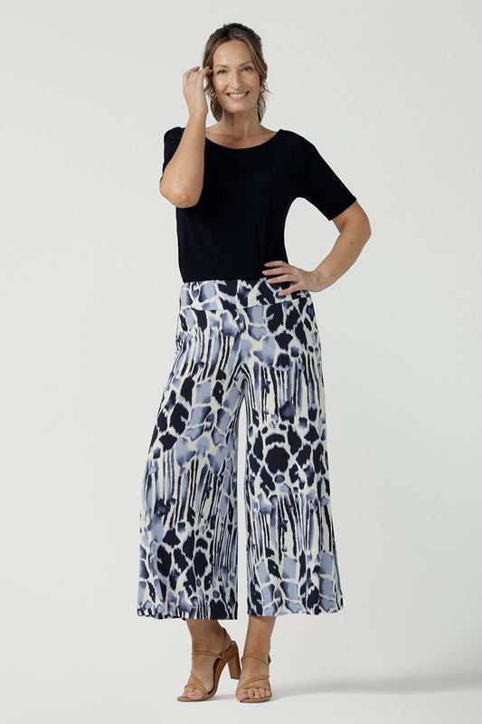 A size 10, over 40 woman wears cropped, wide leg culotte pants in blue and white print with a boat neck, short sleeve jersey top in navy blue. Great summer pants, these culottes are easy care and comfortable as work wear pants or for casual wear. Made in Australia by Australian women's clothing brand, Leina & Fleur.