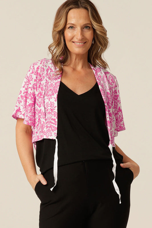  A cropped length jersey, shrug-style jacket with flutter sleeves and a ribbon tie. The Carli Shrug is the best jacket for summer arm coverage! 