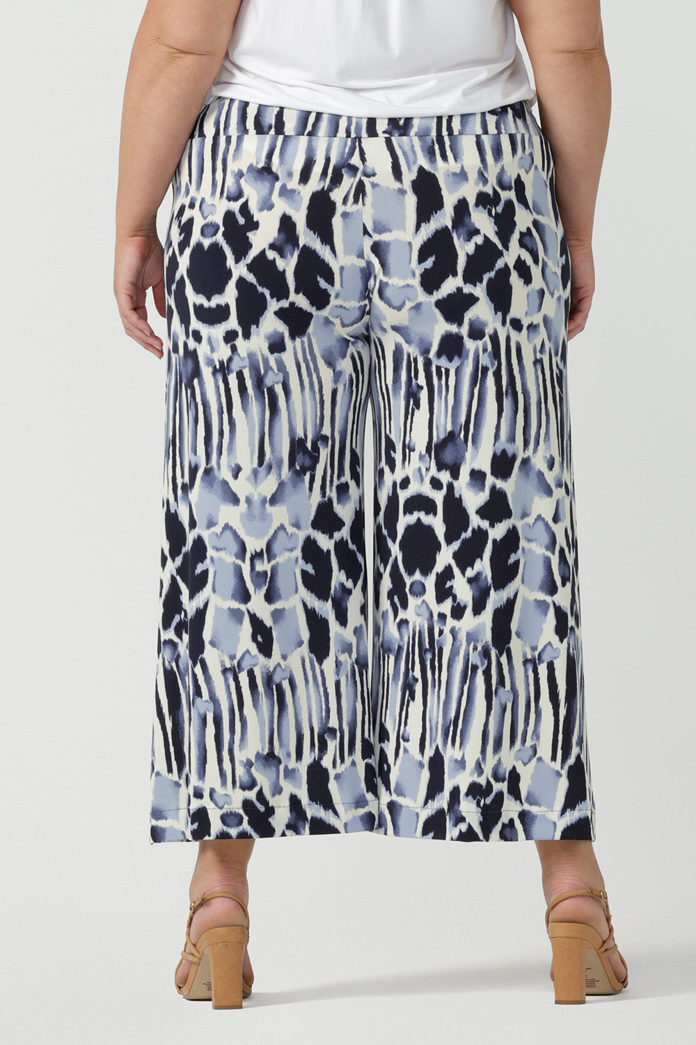 Back view of cropped, wide leg culotte pants in blue and white print are shown in a size as good plus size pants for curvy women. Great summer pants, these culottes have a pull-on waistband and side pockets. Easy care pants, they are comfortable as work wear pants or for casual wear. Made in Australia by Australian women's fashion label, Leina & Fleur