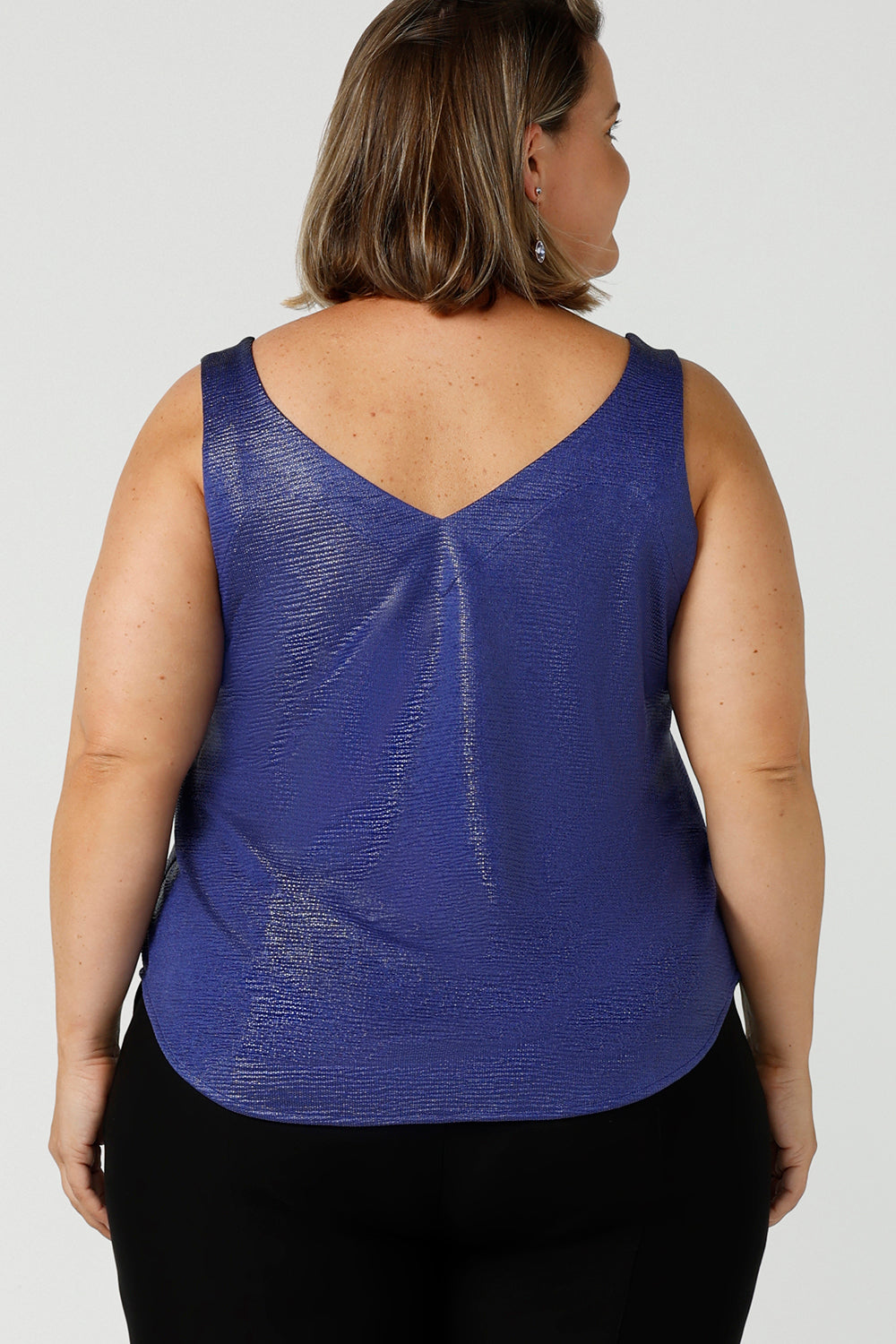 Back view of a plus size 18, fuller figure woman wearing a cobalt Xanadu cami top with wide shoulder straps. Made in Australia by Australian and New Zealand women's clothing company, this shimmer jersey top wears well with evening and occasion-wear skirts, pants and suit jackets.