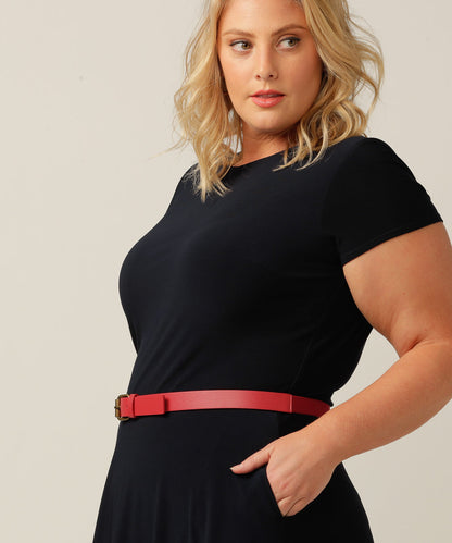 plus size model wears petite red leatherette belt around the waist with silver buckle over a black dress