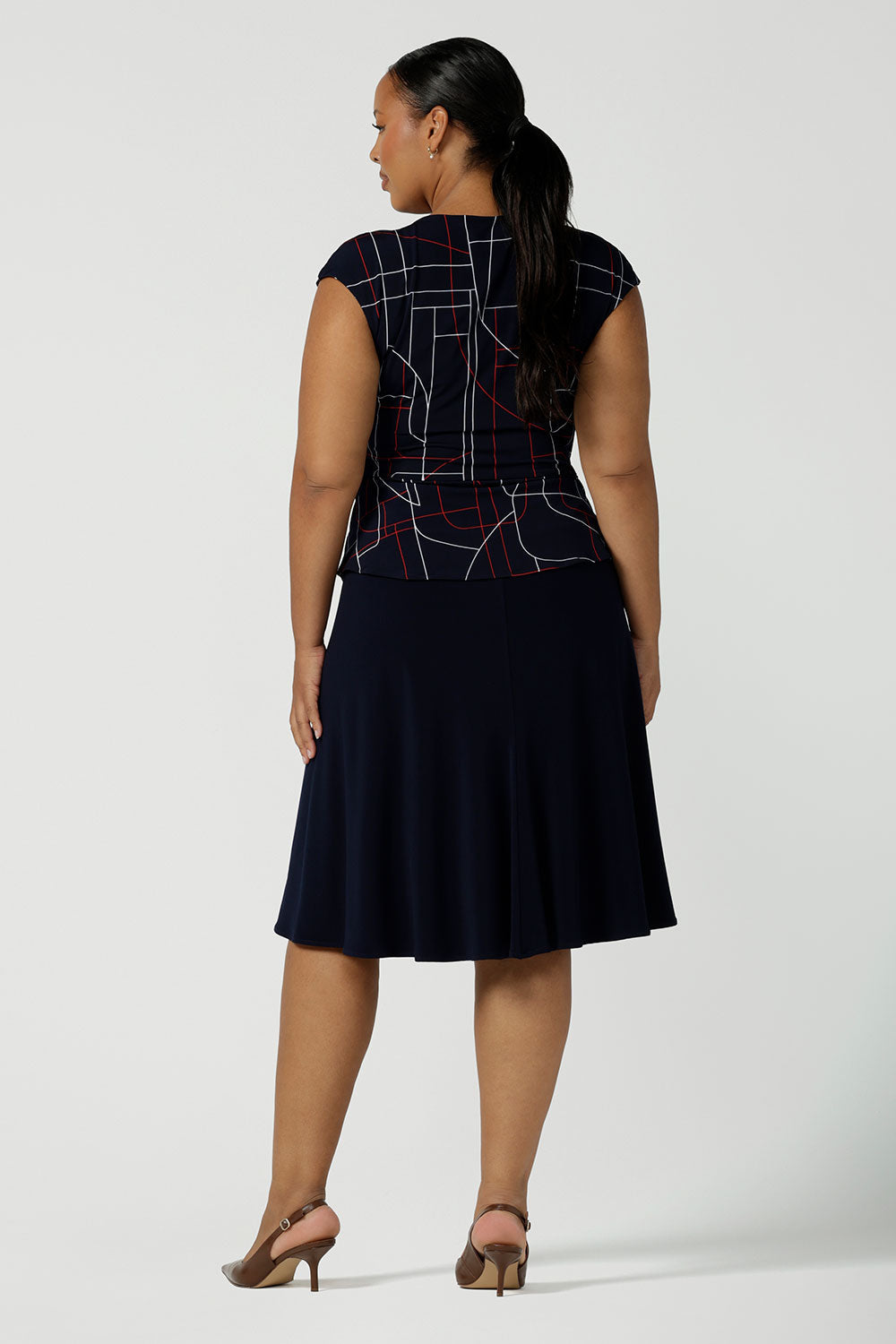 Back view of a size 16 curvy woman wearing the Cassidy skirt in Navy. A comfortable work wear wear corporate casual skirt. Style back with a Finley top in Abstract. Made in Australia for women size 8 - 24.