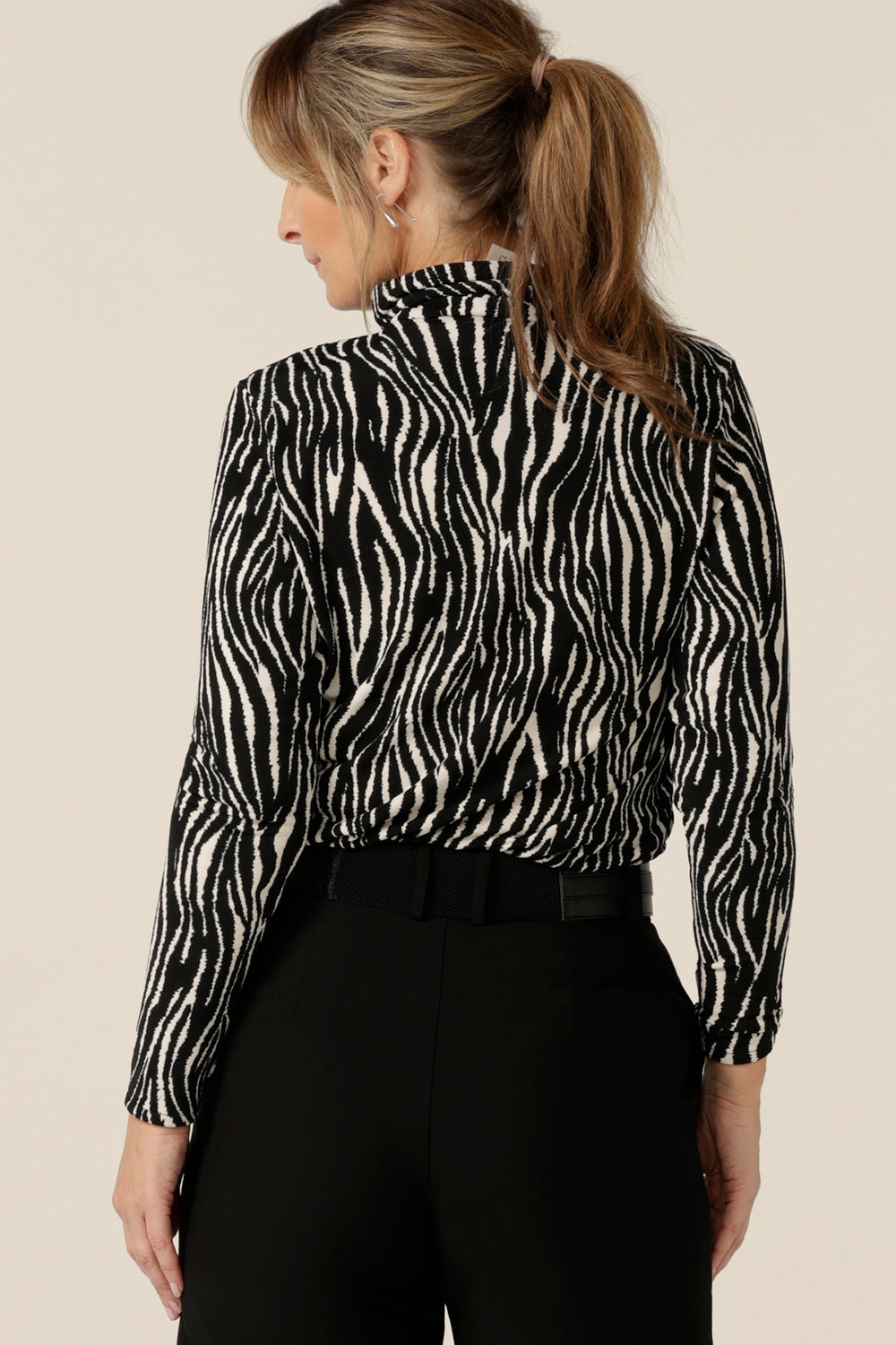 Back view of a long sleeve, polo neck top in black and white zebra print jersey. Made in Australia by Australian and New Zealand women's clothing brand, L&F, shop this work top in sizes 8 to 24.