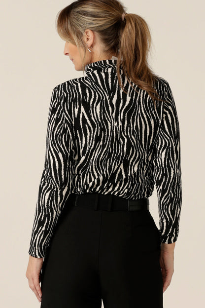 Back view of a long sleeve, polo neck top in black and white zebra print jersey. Made in Australia by Australian and New Zealand women's clothing brand, L&F, shop this work top in sizes 8 to 24.
