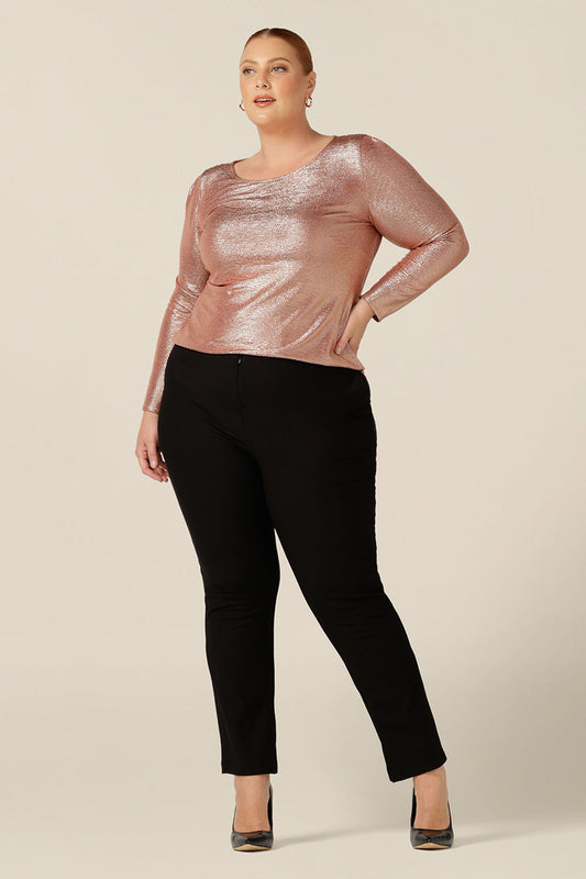 A sparkly top for evening and occasionwear, the Jody Top in a shimmering pink jersey top has a high scoop neck and long sleeves. This women's top is shown in a size 18 and worn with slim leg black evening pants. Made in Australia by Australian and New Zealand women's clothing brand, L&F, this evening top pairs well with skirt and pants for a cocktail party outfit with a sparkle!