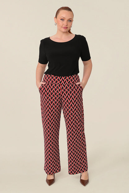 Good pants for curvy women, these geometric print pants are straight cut, wide leg trousers with a wide, pull-on waistband. Styled for work wear, these office pants are worn with a black short sleeve top. Made in Australia, shop online now in sizes 8 to 24.