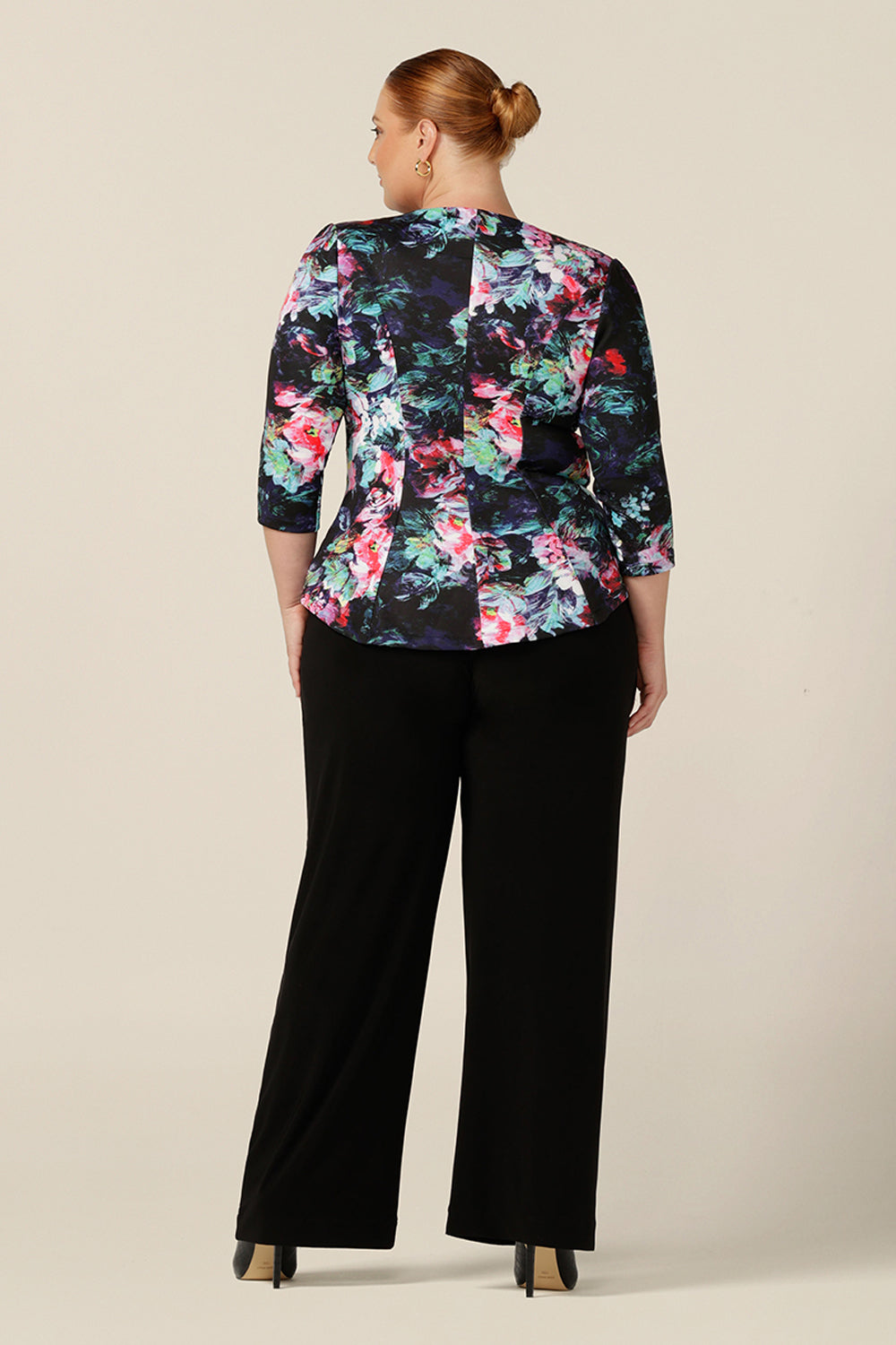 Back view of a soft tailoring top, by Australian and New Zealand women's clothing brand, L&F, the Saxon Top has a round neckline, 3/4 sleeves and tailored panelling. The stretch scuba fabric makes for comfortable workwear tailoring, as shown on this fuller figure woman. Shop now with free shipping to New Zealand.