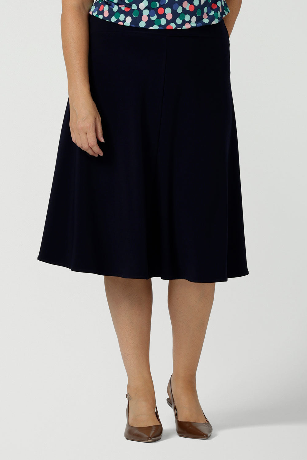 Close up of a size 12 woman wears the Cassidy skirt in Navy. A comfortable work wear wear corporate casual skirt. Made in Australia for women size 8 - 24.